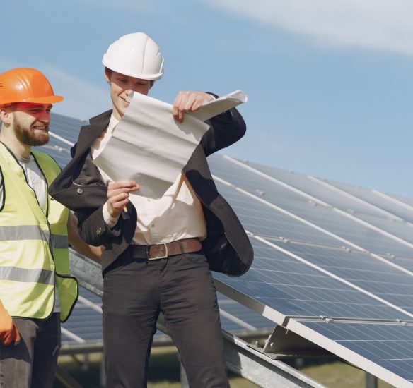 Businessman and worker near solar energy batteries. Business client showing photovoltaic detail to foreman. Two men making deal.